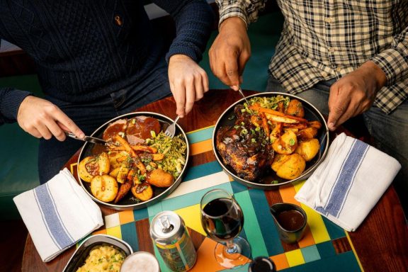 Caribbean inspired Sunday Roast dinners on colourful table