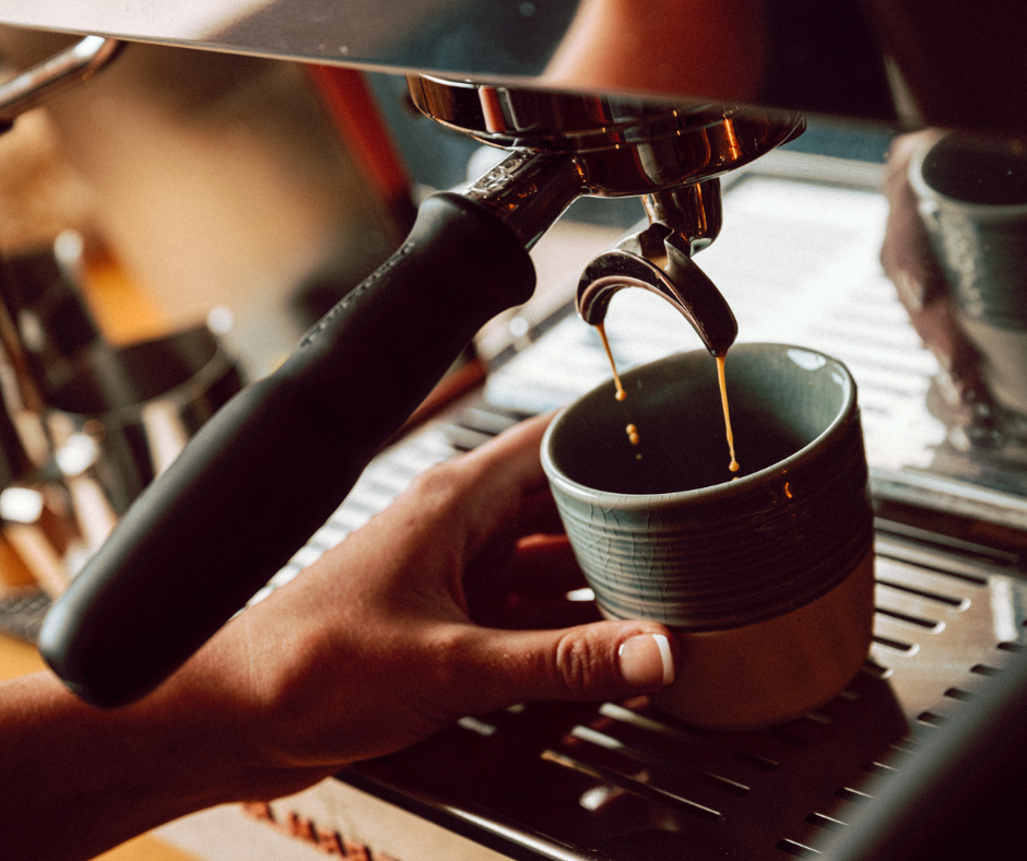 Espresso pouring into coffee cup