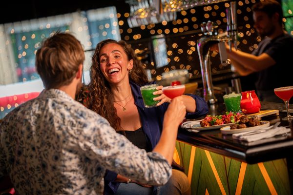 Couple at Bar with Food and Cocktails Christmas Lights